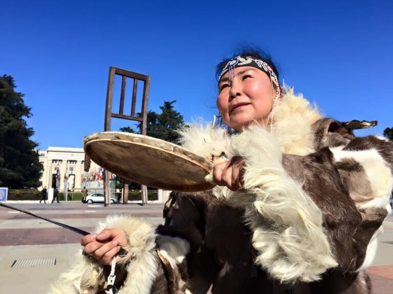 the indigenous drummer and throat singer, Olga, perfoming in full animal skin attire in front of the UN at the broken chair in Geneva